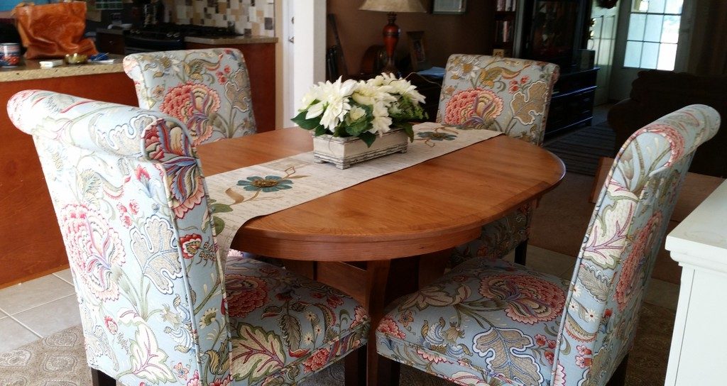 Cherry Imperial Single Pedestal Dining Table from Amish Furniture Factory with flowered, fully-upholstered chairs