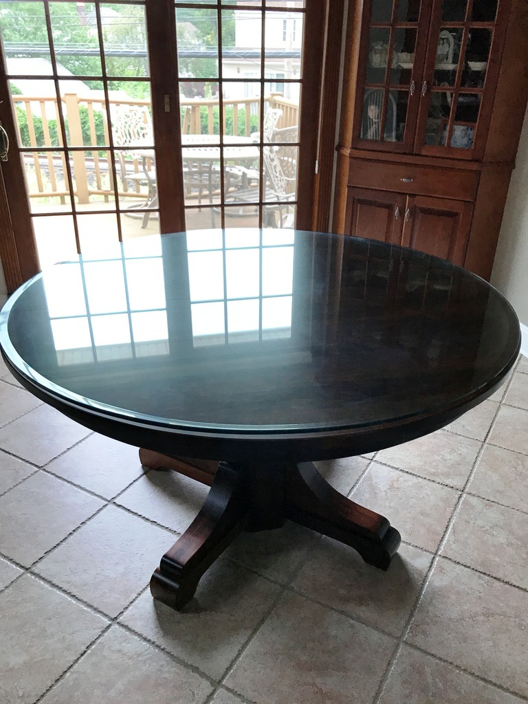 The Monteray Dining Table is a round, single pedestal table when there are no leaves in—Amish Furniture Factory