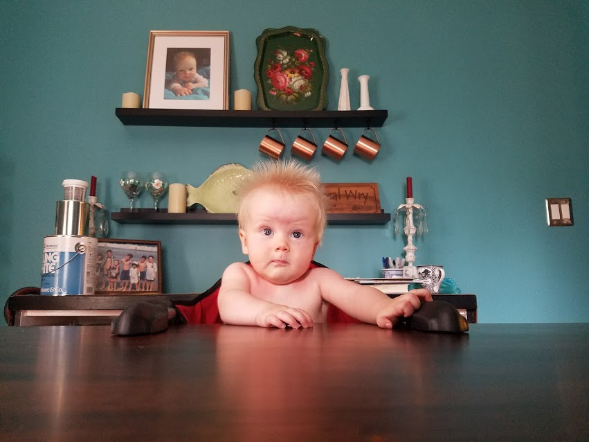 A baby sitting at a Laurie's Leg Dining Table from Amish Furniture Factory