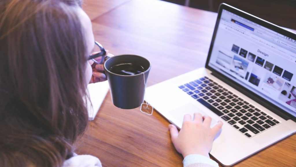 Woman drinking coffee while browsing woodworking website