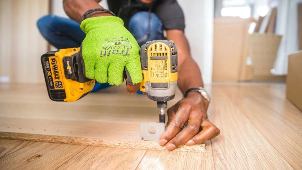 Person using dewalt cordless impact driver on brown board for woodworking