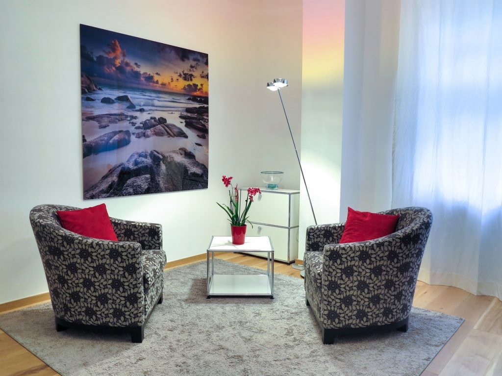 Two living room chairs facing each other on a rug with a side table diagonally between them