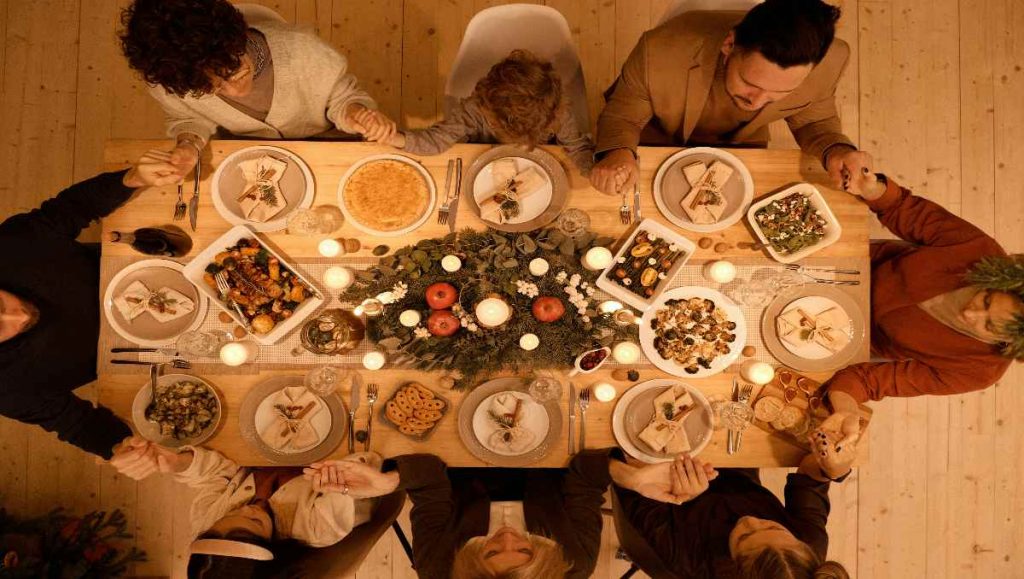 Top View of a Family Praying in the dining table Before Christmas Dinner