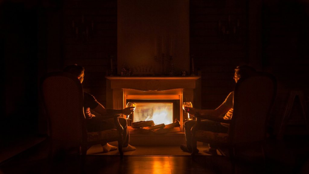 An Amish couple sitting in front of the  fireplace