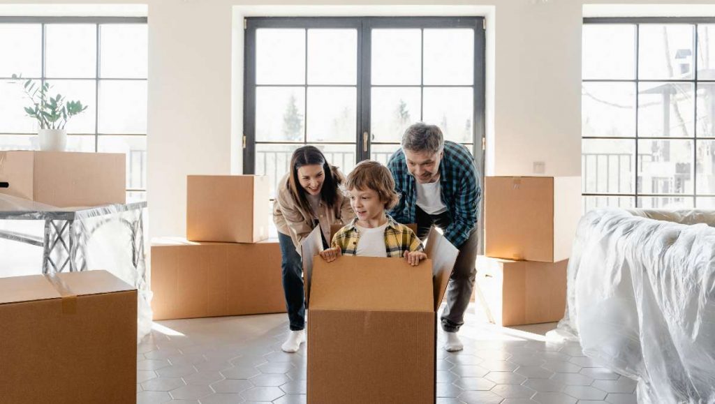 A couple looking at their son inside the box during moving day
