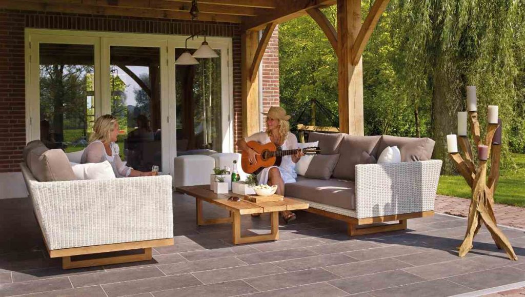 Two women sitting on outdoor sofa