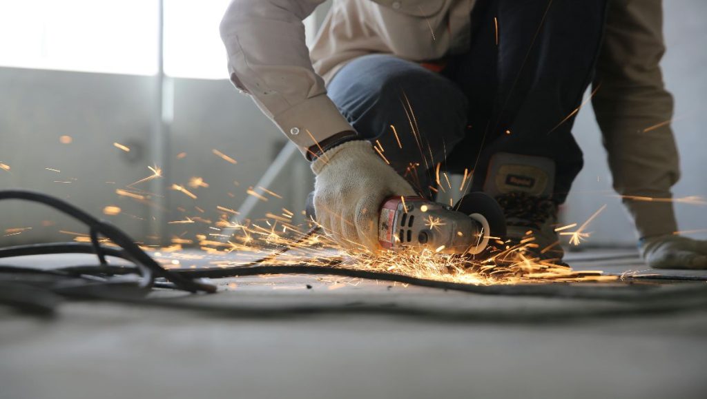 Person holding grinder while welding